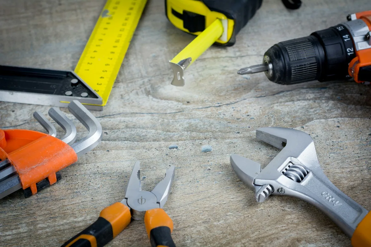 Hand tools laid out on a workbench - the kind of setup that runs fine on a notebook and a phone for a working handyman doing under 5 jobs a week.